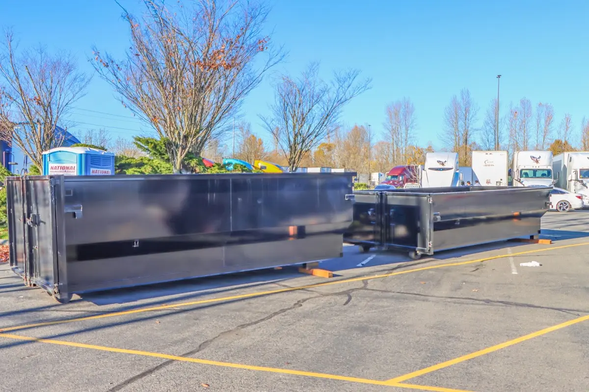 Professional dumpster rental service with roll-off container on residential driveway in West Lealman